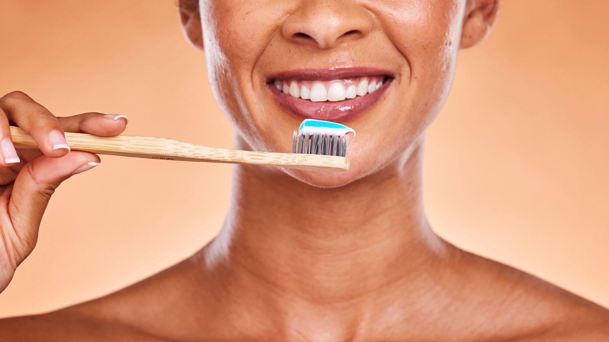 A woman holding a toothbrush and smiling emphasizing prevention and is gingivitis contagious information