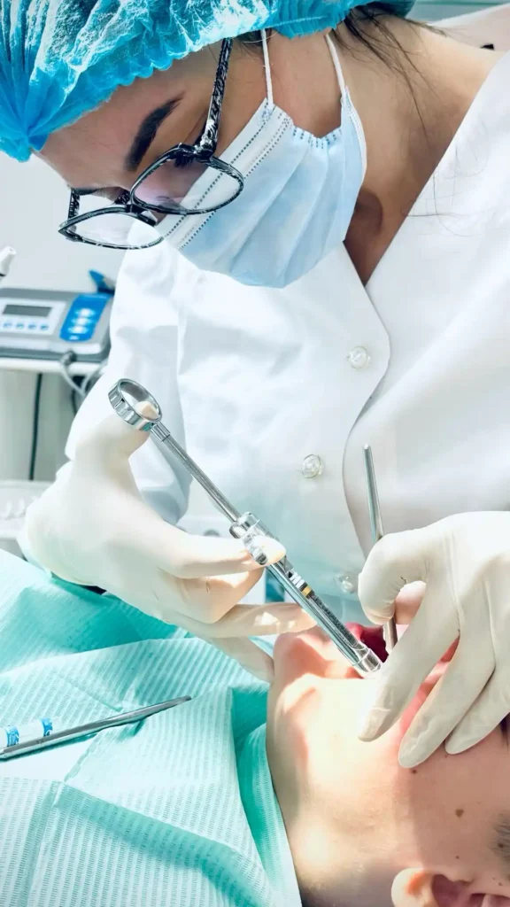 Glendale dentist in surgical cap and mask carefully preparing a patient for treatment